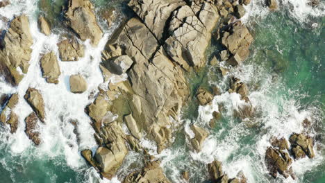 Aerial-view-of-sea-waves-and-fantastic-rocky-coast,-Praia-Armacao,-Florianopolis,-Santa-Catarina,-Brazil