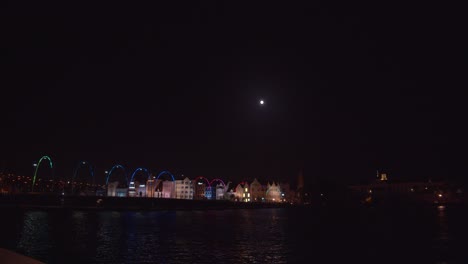 Willemstad,-La-Capital-De-Curacao,-Con-El-Puente-Queen-Emma-En-Primer-Plano-Y-La-Luna-Saliendo-Sobre-La-Ciudad