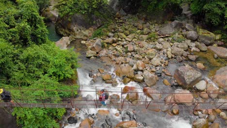 4k-Aerial-flying-above-people-walking-on-the-suspension-bridge-in-the-forest-of-Cheerapunji,-Meghalaya,-India