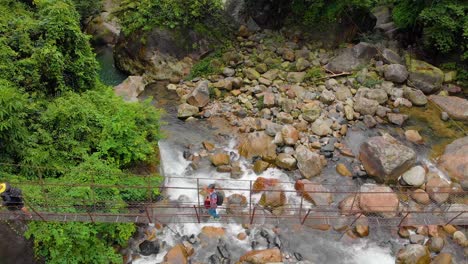 4k-Vuelo-Aéreo-Sobre-Personas-Caminando-En-El-Puente-Colgante-En-El-Bosque-De-Cheerapunji,-Meghalaya,-India