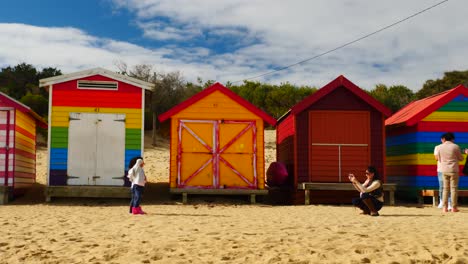 Tourists-walking-and-taking-photo-at-Brighton-Bathing-Boxes,-Melbourne,-Australia