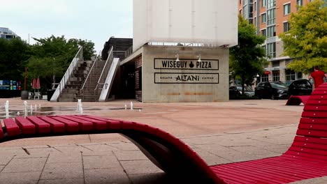 Asientos-Modernos-De-Color-Rojo-Brillante-Cerca-De-Las-Fuentes-En-Una-Plaza-Fuera-De-Los-Restaurantes-En-El-área-De-Navy-Yard-De-Washington,-D.C.