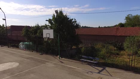 Leerer-Sommerbasketballplatz-Und-Bank-Daneben