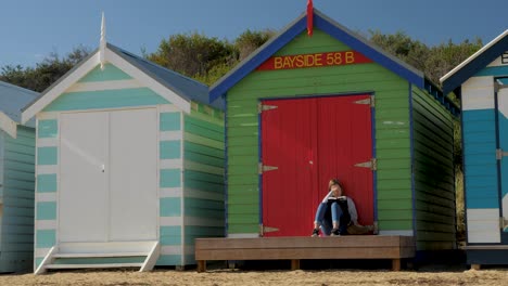 Tourists-walking-and-taking-photo-at-Brighton-Bathing-Boxes,-Melbourne,-Australia