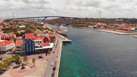 Eine-Brücke-über-Die-Bucht-Von-Sint-Anna-Mit-Zwei-Kreuzfahrtschiffen,-Die-Im-Hafen-Angedockt-Sind