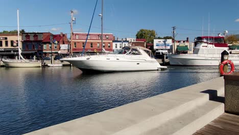Boat,-yacht-enters-Spa-Creek,-Ego-Alley-with-historic-storefronts
