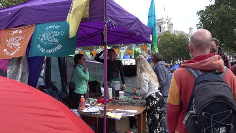 people-shop-at-a-stall-set-up-in-the-road-during-Extinction-Rebellion-protests-in-London,-UK