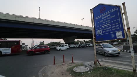Der-Verkehr-Passiert-An-Einer-Ampel-Unter-Einer-Überführung-In-Neu-Delhi,-Indien