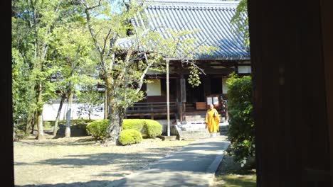 Monk-walkng-in-a-Japanese-garden-from-a-temple-in-Kyoto,-Japan-soft-lighting-slow-motion-4K