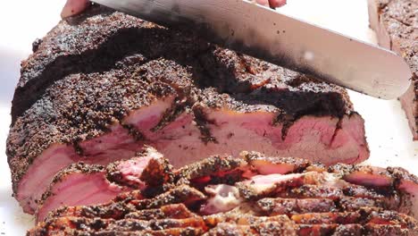 Trying-to-determine-the-best-way-to-continue-cutting-a-brisket-towards-the-point,-shows-many-pieces-that-were-sliced-beforehand