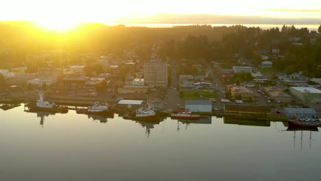 Drone-clip-of-Coos-Bay,-Oregon,-sun-setting-over-hill