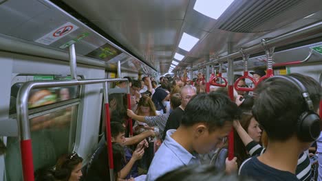 Viajeros-En-Un-Tren-De-Transporte-Público-Lleno-De-Gente-O-En-Un-Tren-Mrt-En-La-Red-De-Transporte-Subterráneo-De-Hong-Kong