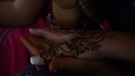 Henna-hand-tattoo-with-tradicional-ink-in-the-Sahara-Desert,-Morocco