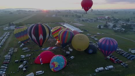 Luftaufnahme-Von-Heißluftballons,-Die-Sich-An-Einem-Sommermorgen-Bei-Einem-Heißluftballonfestival-Füllen-Und-Abheben