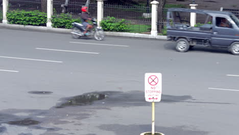 Urban-city-traffic-goes-on-behind-a-no-stopping-sign-on-the-streets