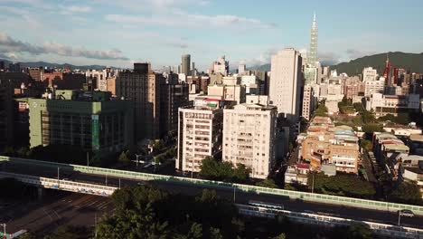 Moderne-Asiatische-Metropole-Zur-Goldenen-Stunde,-Antenne,-Taipeh-Taiwan,-Daan-Forest-Park-Und-Jianguo-Hochstraße-Mit-Blick-Auf-Das-Wahrzeichen-Des-Turms