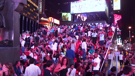 Los-Turistas-Caminan-En-La-Famosa-Plaza-De-Tiempos-En-La-Noche-De-La-Ciudad-De-Nueva-York