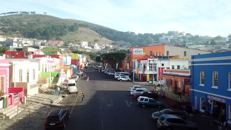 Toma-Aérea-De-Drones-De-Bokaap-Wale-Street-Y-Punto-Verde-Entre-Strand-Street-Y-Rose-Street-En-Ciudad-Del-Cabo,-Sudáfrica-En-Un-Soleado-Día-De-Cielo-Azul