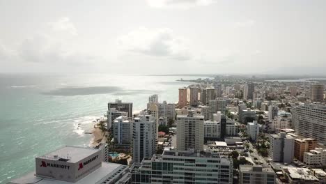 San-Juan,-Puerto-Rico,-Vista-Aérea-De-La-Costa,-Playa-De-Arena,-Hoteles-Y-Edificios-Bajo-Un-Hermoso-Cielo