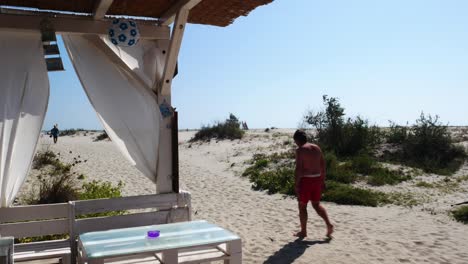 Locked-shot-of-Beach-bar-and-tourists-on-the-beach-of-Sfantu-Gheorghe,-Black-sea
