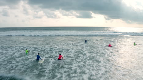 Drone-Aéreo-De-4k-Volando-Bajo-Y-Rápido-Sobre-Un-Grupo-De-Surfistas-En-El-Mar