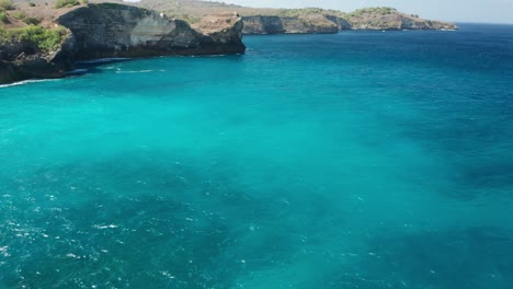 Acantilados-Impresionantes-Y-Agua-De-Mar-Azul-Claro-De-Bali-En-La-Playa-Rota-De-Pasih-Uug,-Antena,-Isla-De-Nusa-Penida-Indonesia