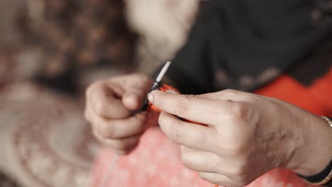 Close-up-of-woman's-hands-knitting-with-two-needle-crafts-and-red-wool