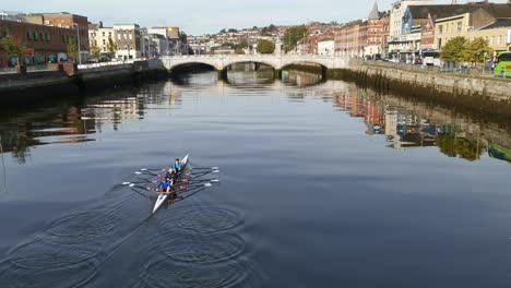 Día-Soleado-En-La-Ciudad-De-Cork,-Irlanda-Con-Un-Equipo-De-Remo-Practicando-En-El-Río-Lee