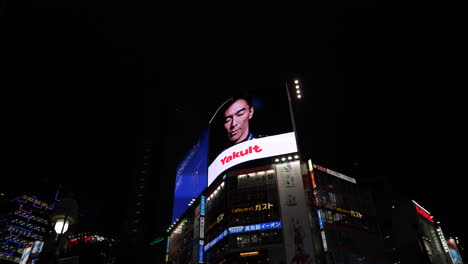 Neon-advertising-signs-on-top-of-the-buildings-near-Shibuya-Crossing-at-night,-Tokyo