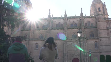 Salamanca,-Spain---December-7,-2019:-Couple-of-tourists-watching-the-beautiful-views-of-the-cathedral-in-a-beautiful-backlight-with-the-flare-of-the-sun