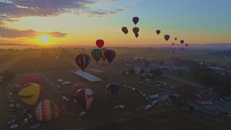 Luftaufnahme-Eines-Morgendlichen-Starts-Von-Heißluftballons-Bei-Einem-Ballonfestival-Vom-Befüllen-Bis-Zum-Abheben,-Wie-Von-Einer-Drohne-Gesehen