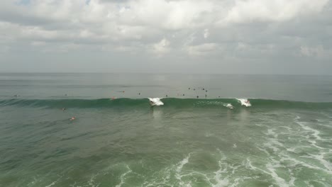 Aerial-View-of-Surfers-in-Indian-Ocean-Surfing-and-Waiting-For-Waves,-Bali-Indonesia