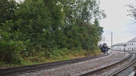 Close-Up-of-an-Antique-Steam-Engine-Slowly-Pulling-Away-Puffing-Black-Smoke