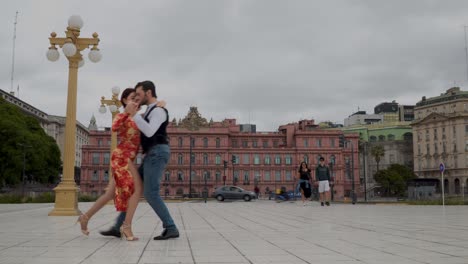 Dos-Bailarines-Profesionales-De-Tango-Bailando-Con-Casa-Rosada-En-El-Fondo