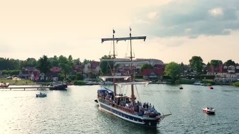 Orbiting-around-a-brige-type-sailing-ship-full-of-passengers-standing-in-the-city-bay