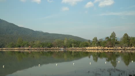 Hermoso-Lago-Huay-Tung-Tao-En-Chiang-Mai-Con-Un-Exuberante-Telón-De-Fondo-De-Montaña,-Mostrando-Las-Cabañas-De-Paja-En-El-Frente-Del-Lago