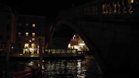 Beautiful-night-view-of-the-Grand-Canal-and-Vaporetto-boats-transporting-tourists-under-the-Scalzi-Bridge