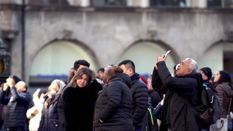 People-listening-and-watching-the-famous-Glockenspiel-at-Munich-Marienplatz