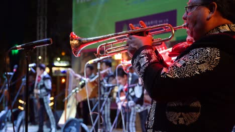 Mariachi-band-trumpet-player-in-focus-with-rest-of-the-band-in-depth-of-field-blur-on-stage-in-Merida,-Mexico