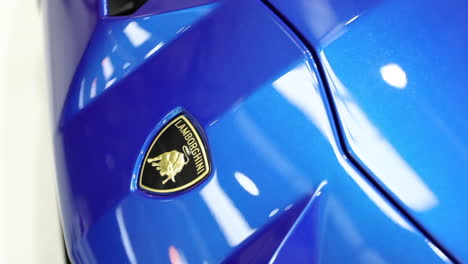 Gelbes-Lamborghini-Abzeichen-Auf-Blauem-Supersportwagen