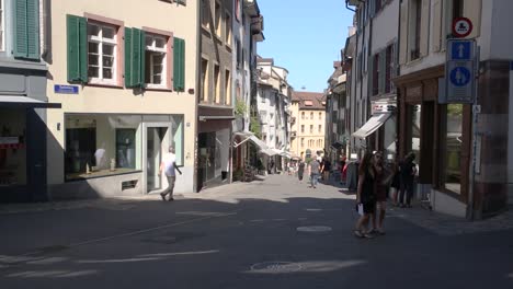 Narrow-street-of-Basel-old-town,-people-walking,-Switzerland
