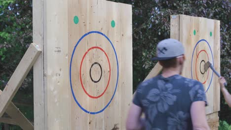 Two-men-throwing-axes-to-a-target-and-hits-a-bullseye