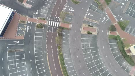 Aerial-view-above-urban-shopping-centre-empty-parking-spaces-closed-COVID-virus-town-lock-down-birds-eye-pull-back