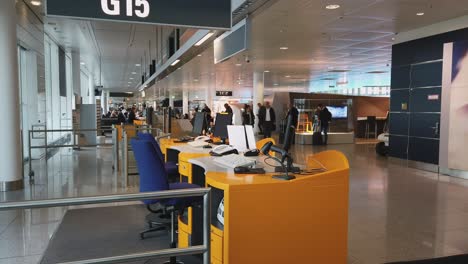Leuchtend-Oranger-Gate-Schalter,-Während-Passagiere-Durch-Einen-Internationalen-Flughafen-Gehen