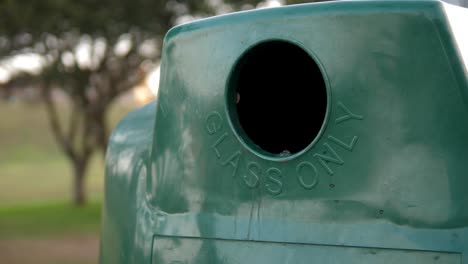 Glass-bottle-being-placed-into-recycling-bin