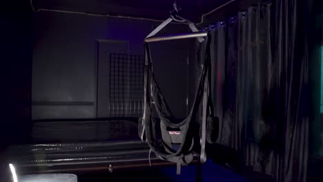 Swing-for-bondage-in-a-dark-room-near-bed