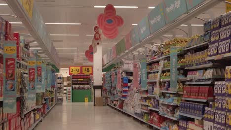 Slow-motion-interior-empty-UK-supermarket-passing-closed-Easter-egg-aisle