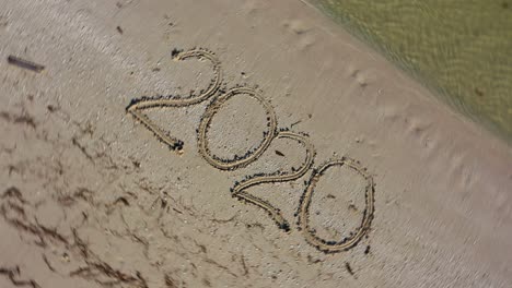 Twenty-Twenty-written-in-the-sand-and-spinning-counterclockwise-making-it-a-crazy-year