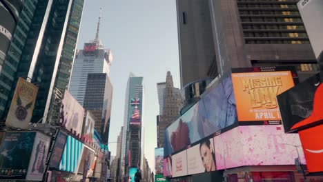 Vista-Giratoria-De-ángulo-Bajo-De-Innumerables-Vallas-Publicitarias-Digitales-Intermitentes-En-Times-Square,-Nueva-York,-A-última-Hora-De-La-Tarde