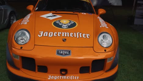 Sweeping-Shot-of-an-Orane-Rauh-Welt-Begriff-Porsche-at-Luxury-Car-Show